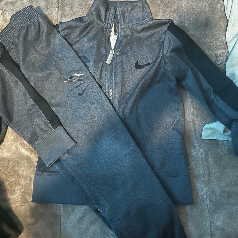 Nike kids' two-piece Dri-FIT tracksuit set in a dark gray color.